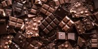 Assorted chocolate bar and chunks, background. Flat lay with a multitude of chocolate kinds. Delicious cocoa dessert. Baking chocolate collection.